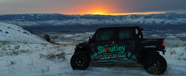 off-road vehicle with rugged accessories driving through mud at sunset in wild terrain